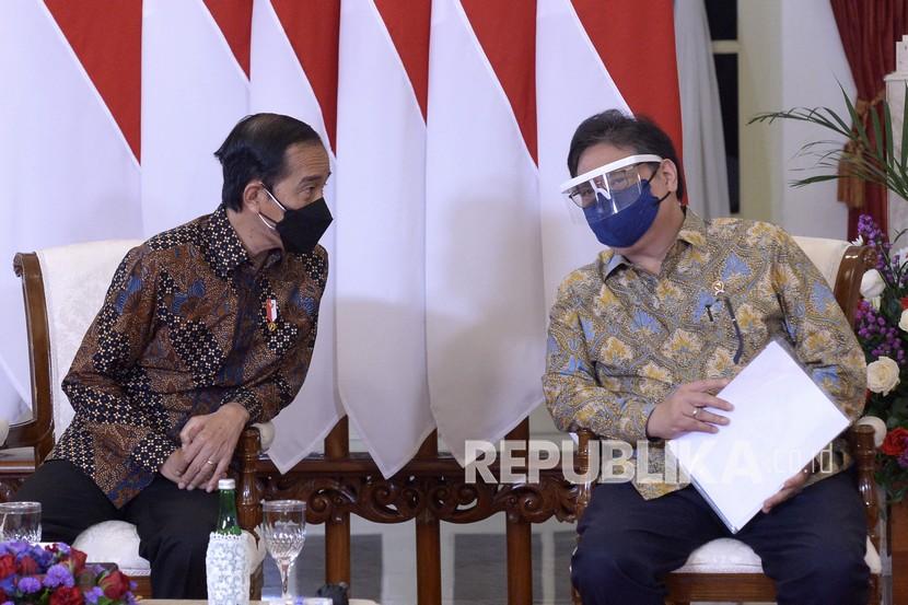 Presiden Joko Widodo (kiri) berbincang dengan Menko Perekonomian Airlangga Hartarto (kanan). Pemerintah menyatakan, penyaluran bansos beras 10 kg sudah terealisasi 100 persen.
