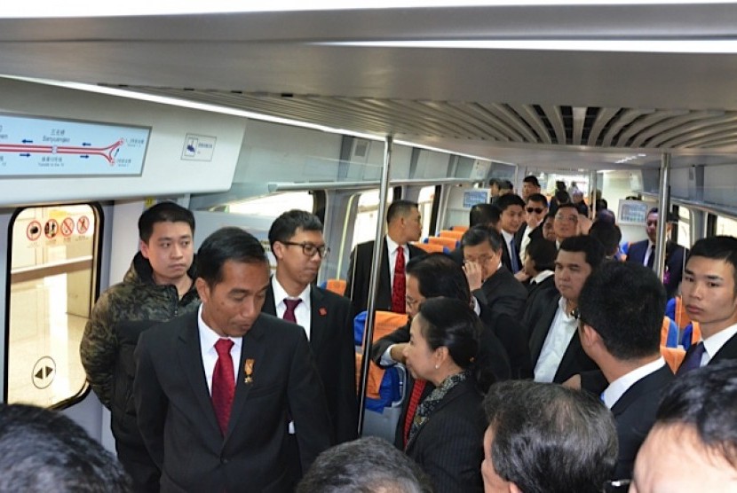 Presiden Joko Widodo (kiri) berbincang dengan Menteri BUMN Rini Soemarmo (kanan) dalam kereta api bawah tanah (subway) saat tiba di terminal 3 Bandara Internasional Capital Beijing, di Beijing, Kamis (26/3).