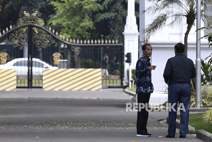 Presiden Joko Widodo (kiri) berbincang dengan Menteri Koordinator Bidang Kemaritiman Luhut Panjaitan (kanan) di Kompleks Istana Kepresidenan, Jakarta, Senin (22/4/2019).