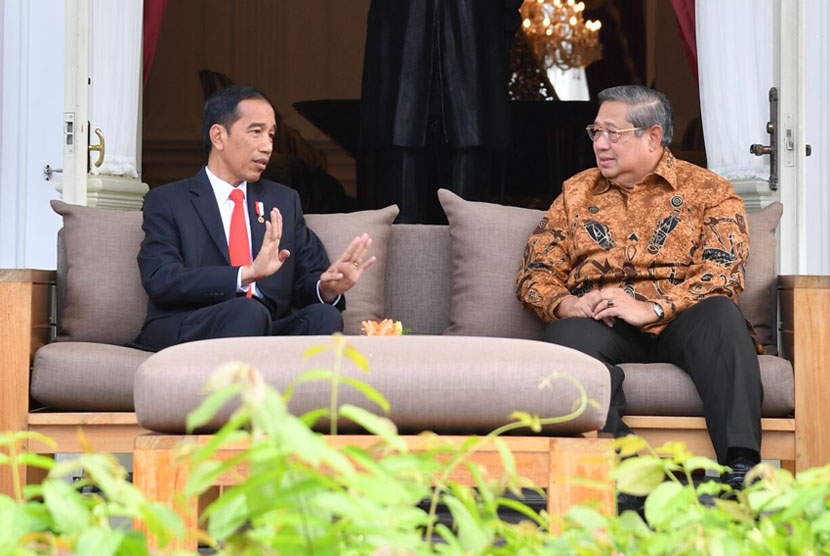 Presiden Joko Widodo (kiri) berbincang dengan Presiden Ke-6 RI Susilo Bambang Yudhoyono (kanan), di teras belakang Istana Merdeka, Jakarta, Jumat (27/10).