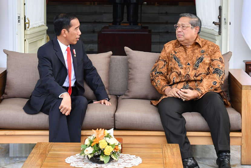 Presiden Joko Widodo (kiri) berbincang dengan Presiden Ke-6 RI Susilo Bambang Yudhoyono (kanan), di teras belakang Istana Merdeka, Jakarta, Jumat (27/10).