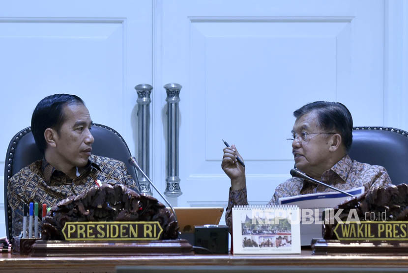Presiden Joko Widodo (kiri) berbincang dengan Wakil Presiden Jusuf Kalla sebelum memimpin rapat terbatas tentang perkembangan implementasi program pengentasan kemiskinan di Kantor Presiden, Jakarta, Selasa (25/7). 