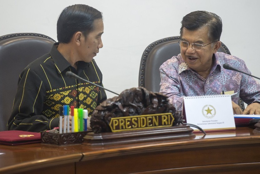 Presiden Joko Widodo (kiri) berbincang dengan Wapres Jusuf Kalla (kanan) sebelum memimpin rapat kabinet terbatas yang membahas soal pengelolaan kawasan perdagangan bebas Batam di Kantor Kepresidenan, Jakarta, Selasa (19/1). 