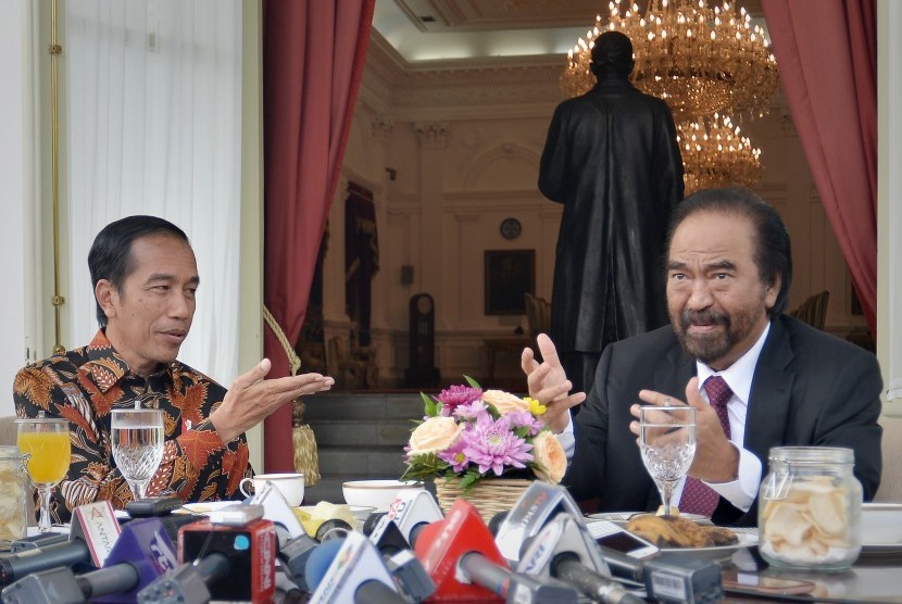 Presiden Joko Widodo (kiri) berdialog dengan Ketua Umum Partai Nasdem Surya Paloh (kanan) saat jamuan makan pagi di beranda belakang Istana Merdeka, Jakarta. 