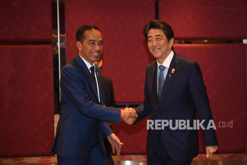 Presiden Joko Widodo (kiri) berjabat tangan dengan Perdana Menteri Jepang Shinzo Abe (kanan) dalam pertemuan bilateral di sela-sela KTT ke-35 ASEAN di Bangkok, Thailand, Senin (4/11/2019). 