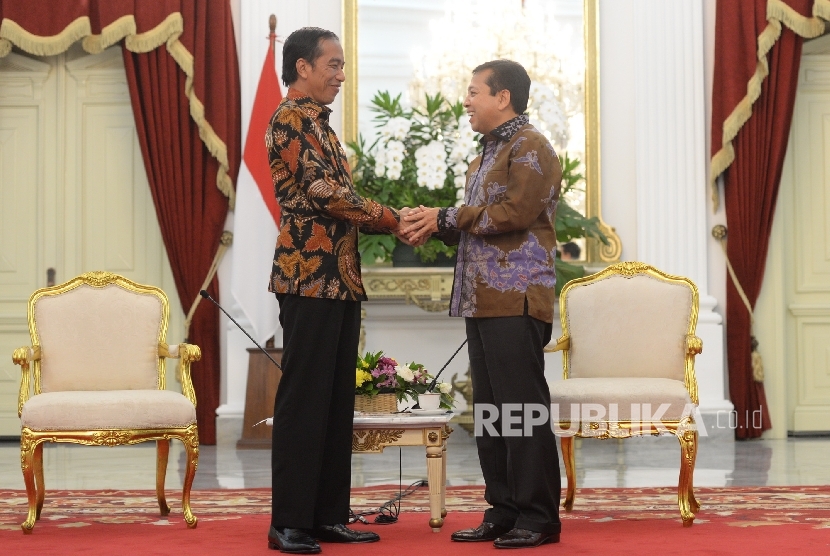 Presiden Joko Widodo (kiri) bersama Ketum Golkar Setya Novanto berjabat tangan usai memberikan keterangan pers usai pertemuan di Istana Merdeka, Selasa (22/11).