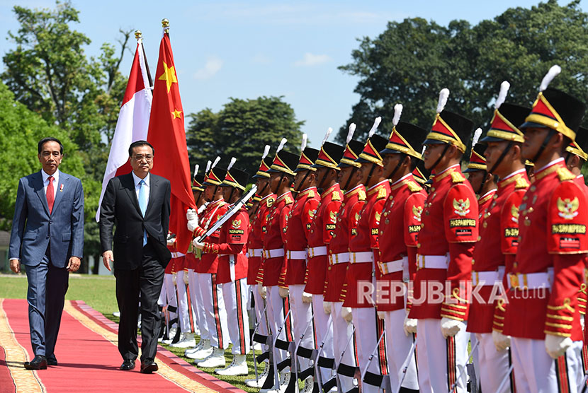Presiden Joko Widodo (kiri) bersama Perdana Menteri Cina Li Keqiang memeriksa pasukan saat kunjungan kenegaraan di Istana Bogor, Jawa Barat, Senin (7/5).