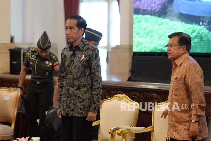 Presiden Joko Widodo (kiri) bersama Wakil Presiden Jusuf Kalla saat tiba di acara Rakor bersama Pangdam serta Kapolda di Istana Negara, Jakarta, Senin (24/10)