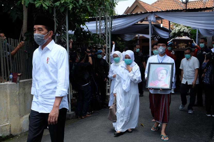 Presiden Joko Widodo (kiri) beserta keluarga dan kerabat berjalan menuju masjid untuk menyolatkan jenazah ibunda Presiden Joko Widodo, Sujiatmi Notomiharjo saat rangkaian prosesi pemakaman di Sumber, Banjarsari, Solo,Jawa Tengah, Kamis (26/3/2020).