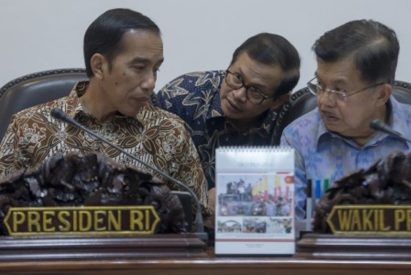 Presiden Joko Widodo (kiri) dan Wapres Jusuf Kalla (kanan) berbincang dengan Seskab Pramono Anung (tengah) sebelum memimpin rapat kabinet terbatas bidang ekonomi di Kantor Kepresidenan, Jakarta, Senin (12/10).