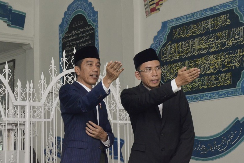 Presiden Joko Widodo (kiri) didampingi Gubernur NTB, TGB Zainul Majdi (kanan), berziarah di makam Pahlawan Nasional Maulana Syekh TGKH Muhammad Zainuddin Abdul Majid di Ponpes NW Pancor, Lombok Timur, NTB, Kamis (23/11). 