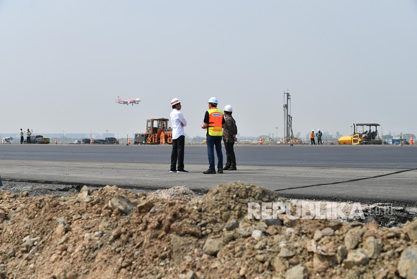 Presiden Joko Widodo (kiri) didampingi Mensesneg Pratikno (kanan) dan Dirut Angkasa Pura II Muhammad Awaluddin (tengah) meninjau meninjau perkembangan pembangunan landasan pacu ketiga Bandara Internasional Soekarno-Hatta di Tangerang, Banten. AP II saat ini sedang fokus mengembangkan bisnis nonaeronautika.