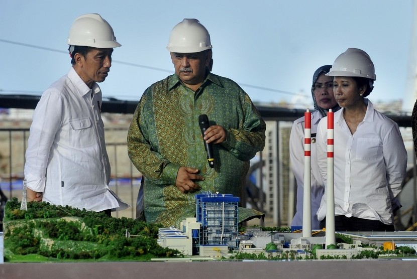 Presiden Joko Widodo (kiri) didampingi Menteri BUMN Rini Soemarno (kanan) dan Bupati Serang Tatu Chasanah (kedua kanan) berbincang dengan Dirut PT PLN Sofyan Basir (kedua kiri) saat meninjau lokasi proyek PLTU (Pembangkit Listrik Tenaga Uap) di Desa Terate, Serang, Banten, Kamis (5/10). 