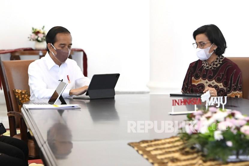 Presiden Joko Widodo (kiri) didampingi Menteri Keuangan Sri Mulyani saat mengisi Surat Pemberitahuan Tahunan (SPT) Pajak tahunan secara online di Istana Bogor, Jawa Barat, Jumat (4/3/2022). Sri Mulyani sebagai Ketua Pansel calon dewan komisioner Otoritas Jasa Keuangan (OJK) mengumumkan 21 nama yang lolos seleksi tahap IV. Dari 21 nama, tiga nama calon bagi masing-masing jabatan.