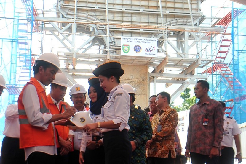 Presiden Joko Widodo (kiri) didampingi Menteri Perhubungan Ignasius Jonan (kedua kiri) membubuhkan tanda tangan usai meninjau pembangunan Light Rail Transit (LRT) di zona 1 Bandara Sultan Mahmud Badaruddin II Palembang, Sumsel, Kamis (3/3).