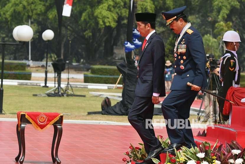 Presiden Joko Widodo (kiri) didampingi Panglima TNI Marsekal TNI Hadi Tjahjanto meninggalkan podium seusai menjadi Inspektur upacara HUT ke-73 TNI di Mabes TNI Cilangkap, Jakarta, Jumat (5/10).