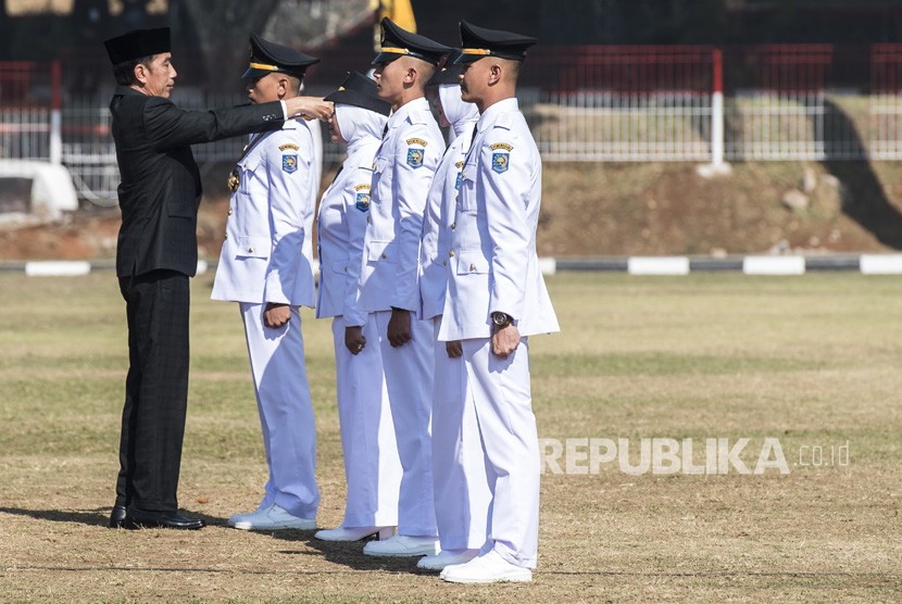 Presiden Joko Widodo (kiri) melantik lulusan angkatan XXV saat wisuda dan Pelantikan Pamong Praja Muda (PPM) Institut Pemerintahan Dalam Negeri (IPDN) Tahun 2018 di Jatinangor, Sumedang, Jawa Barat, Jumat (27/7). 
