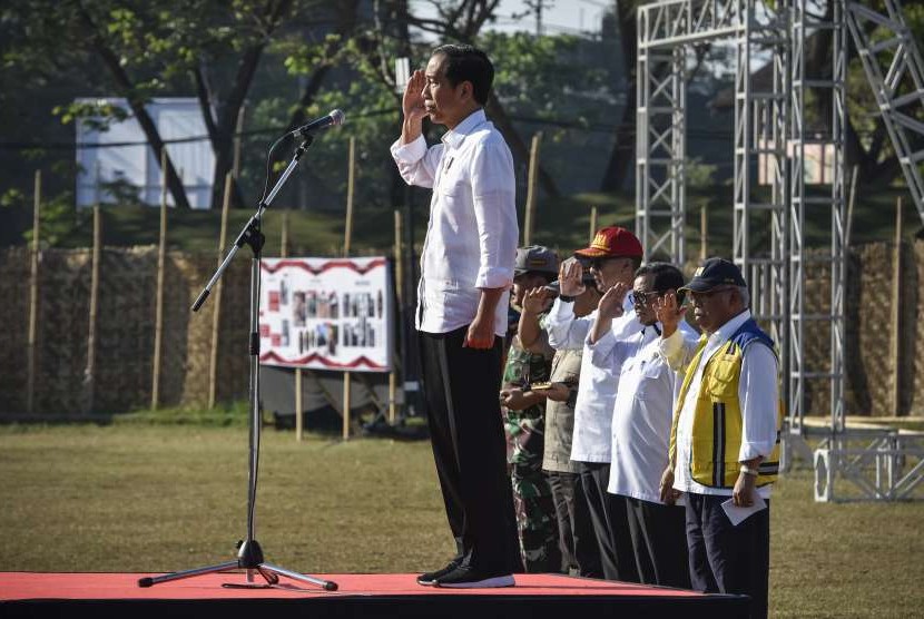 Presiden Joko Widodo (kiri) memberi hormat saat memimpin apel siaga NTB Bangun Kembali di lapangan Kecamatan Gunungsari, Lombok Barat, NTB, Senin (3/9).