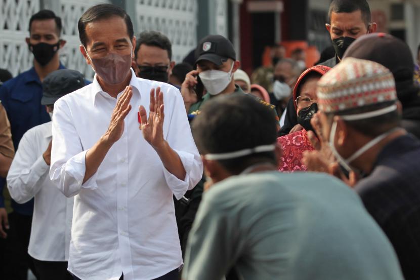 Presiden Joko Widodo (kiri) memberi salam kepada sejumlah nelayan di kampung nelayan Bulak Cumpat, Surabaya, Jawa Timur, Rabu (20/4/2022). Presiden Joko Widodo melakukan kunjungan kerja ke sejumlah lokasi di Jawa Timur salah satunya di kampung nelayan tersebut. 