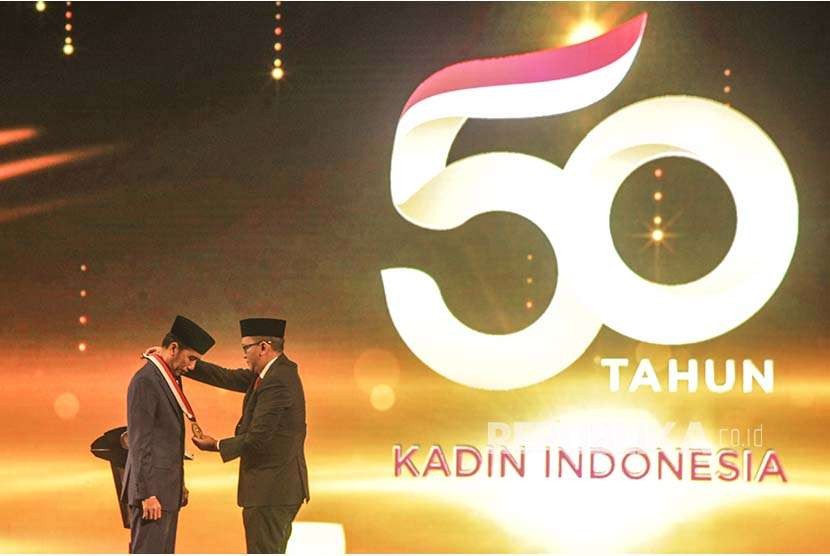 Presiden Joko Widodo (kiri) menerima penghargaan dari Ketua Umum Kadin Rosan P. Roeslani (kanan) pada acara HUT ke-50 Kadin di Jakarta, Senin (24/9). Presiden Joko Widodo menerima penghargaan Tokoh Pemerataan Pembangunan Indonesia.