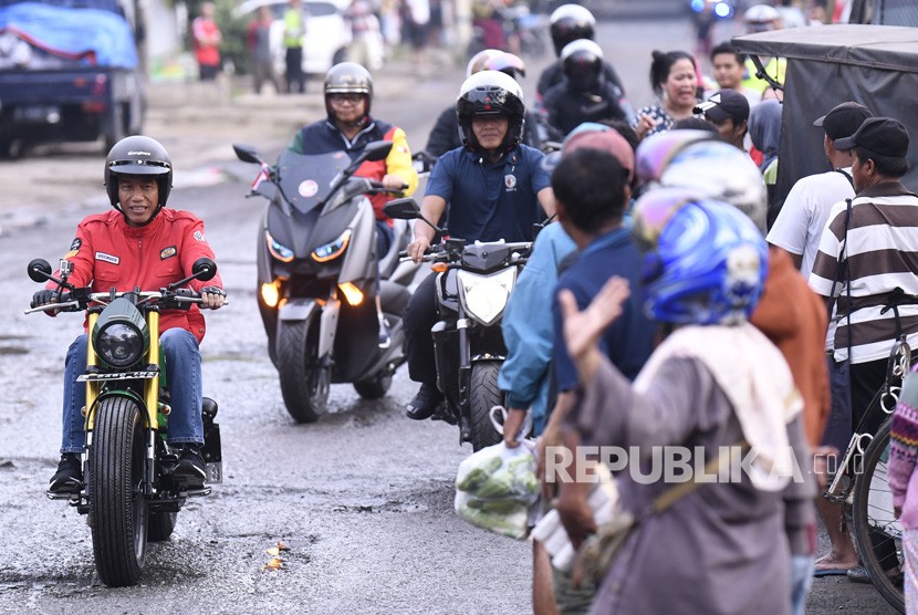 Presiden Joko Widodo (kiri) mengendarai motor menuju Pasar Anyar, Tangerang, Banten, Ahad (4/11/2018). 