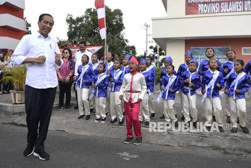 Presiden Joko Widodo (kiri) mengikuti gerakan tari anak-anak saat meninjau Kawasan Ekonomi Khusus (KEK) Bitung di Sulawesi Utara, Jumat (5/7/2019).