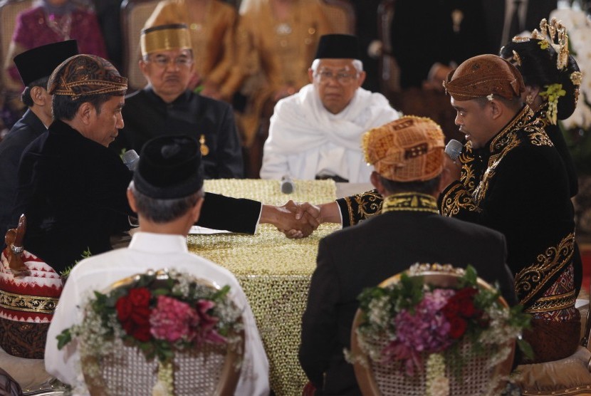 Presiden Joko Widodo (kiri) menikahkan putrinya, Kahiyang Ayu (kanan) dengan Bobby Nasution (kedua kanan) disaksikan Wakil Presiden Jusuf Kalla (kedua kiri) dan Ketua MUI KH Ma'ruf Amin (keempat kanan) saat ijab kabul di Gedung Graha Saba, Sumber, Solo, Jawa Tengah, Rabu (8/11). 