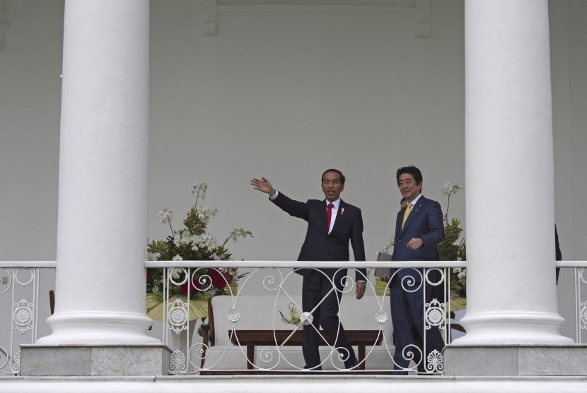 Presiden Joko Widodo (kiri) menyambut Perdana Menteri Jepang Shinzo Abe di Istana Bogor, Bogor, Jawa Barat, Minggu (15/1).