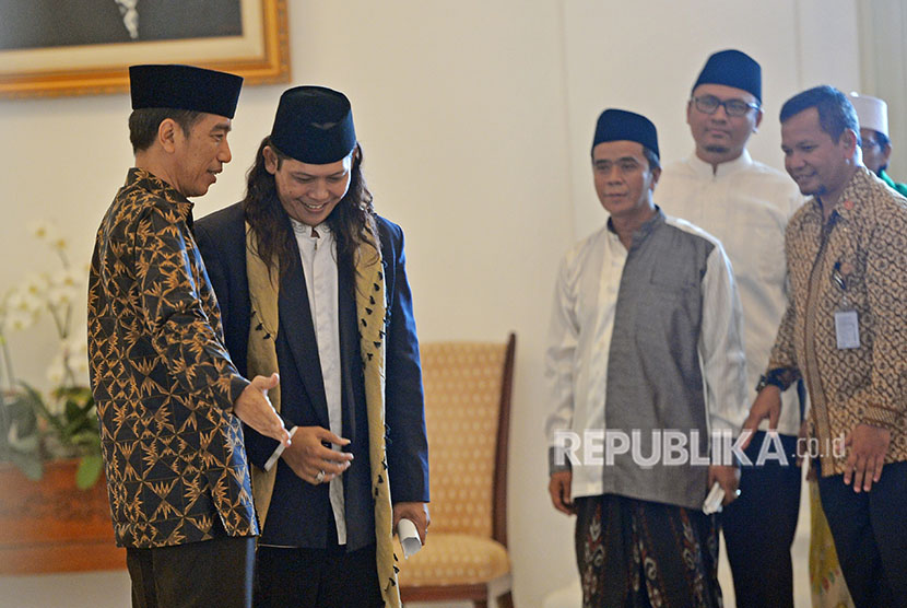 Presiden Joko Widodo (kiri) menyambut ulama sebelum melakukan pertemuan di Istana Bogor, Jawa Barat, Selasa (10/4).