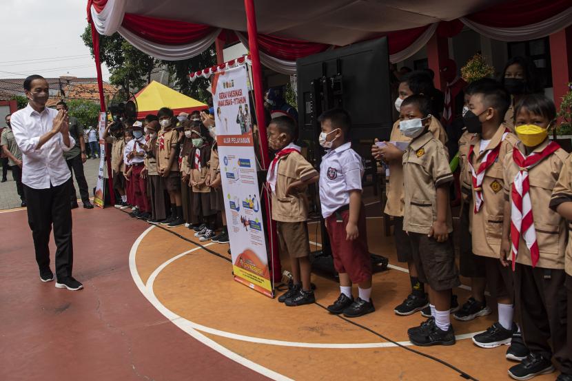 Presiden Joko Widodo (kiri) menyapa sejumlah siswa sekolah dasar yang akan mendapatkan vaksinasi COVID-19 di Kompleks SDN Cideng, Gambir, Jakarta Pusat, Rabu (15/12/2021). Presiden meninjau langsung vaksinasi COVID-19 bagi anak-anak usia 6-11 tahun