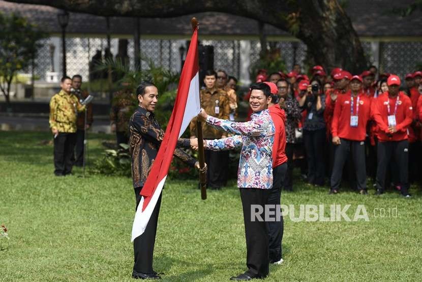 Presiden Joko Widodo (kiri) menyerahkan bendera Merah Putih kepada Ketua Inapgoc Raja Sapta Oktohari (kanan) saat upacara pelepasan kontingen Indonesia untuk Para Games ke-3 Tahun 2018 di halaman tengah Istana Kepresidenan, Jakarta, Selasa (2/10).
