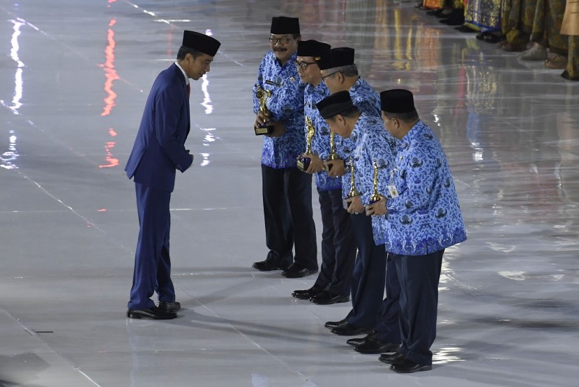 President Joko Widodo (left) hands over Korpri Award during the celebration of the 47th anniversary of the Civil Servant Corps, Jakarta, Thursday.