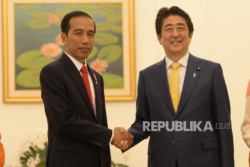 Presiden Joko Widodo (kiri tengah) berjabat tangan bersama Perdana Menteri Jepang Shinzo Abe
