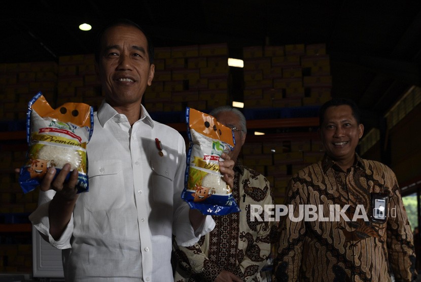 Presiden Joko Widodo (kirii) bersama Kepala Bulog Budi Waseso (kiri) menunjukkan beras kemasarn Bulog saat mengecek stok beras di Kompleks Pergudangan Bulog, Jakarta, Kamis (10/1/2019).