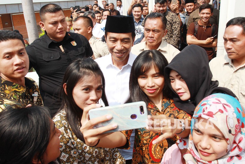 Presiden Joko Widodo melayani jamaah masjid Nurul Barkah berswafoto usai melaksanakan Salat Jumat disela sidak runway 3 di Bandara Soekarno Hatta, Tangerang, Banten, Jumat (21/6/2019).