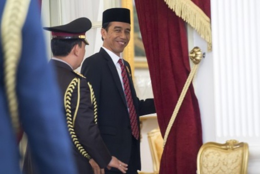 Presiden Joko Widodo melemparkan senyum seraya berjalan memasuki ruang kerjanya untuk menerima pimpinan DPR di Istana Merdeka, Jakarta, Kamis (5/11). 