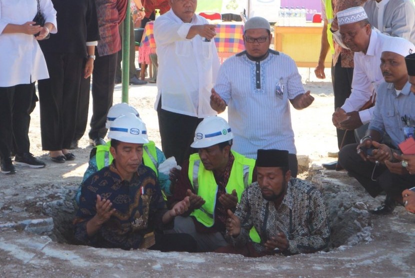 Presiden Joko Widodo meletakkan batu pertama sebagai tanda dimulainya pembangunan kembali atau rekonstruksi Masjid At Taqarrub di Trienggadeng, Pidie Jaya, Kamis (15/12).   Halimatus Sa'diyah