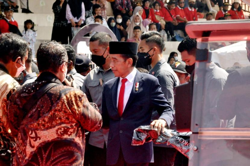 Presiden Joko Widodo membagi- bagikan kaos kepada masyaraka pengunjung di arena Pasar rakyat dalam rangka Hari Bhayangkara ke-76 di Stadion Taruna Akpol, kompleks Akpol Semarang, jawa Tengah, Selasa (5/7).