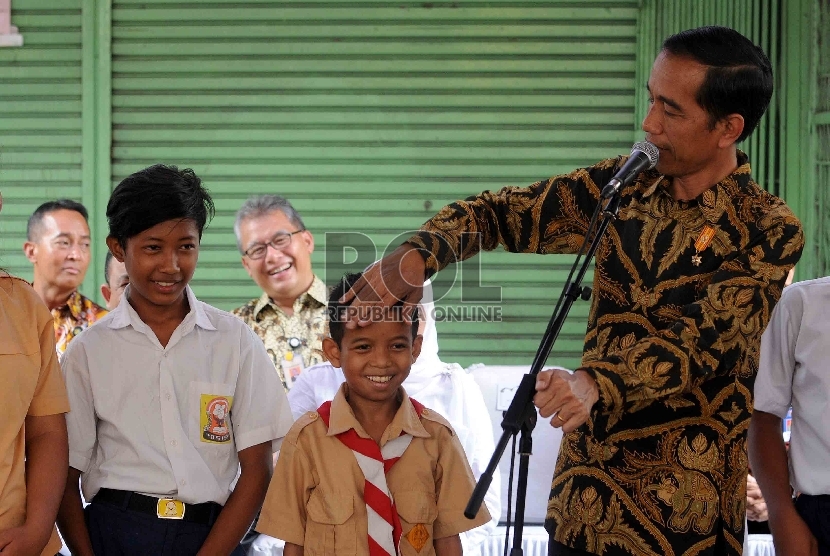 Presiden Joko Widodo membagikan Kartu Indonesia Pintar (KIP) kepada para sswa saat pembagian tiga jenis kartu sakti di wilayah Kampung Melayu, Jakarta Timur, Rabu (13/5).