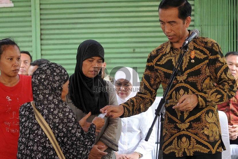 Presiden Joko Widodo membagikan Kartu Keluarga Sejahtera (KKS) kepada warga kurang mampu saat pembagian tiga jenis kartu sakti di wilayah Kampung Melayu, Jakarta Timur, Rabu (13/5).