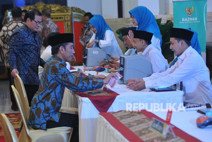 Presiden Joko Widodo membayar zakat penghasilan melalui Baznas di Istana Merdeka, Jakarta, Kamis (16/5).