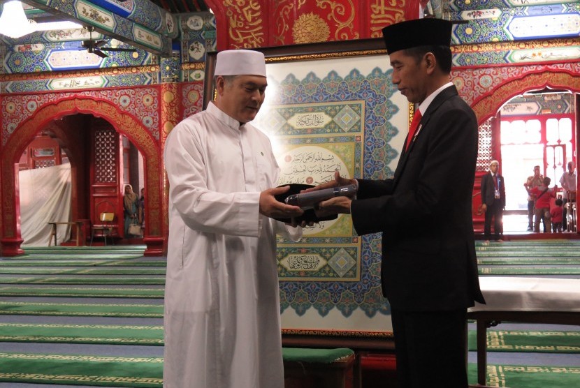 Presiden Joko Widodo memberikan cendera mata berupa songkok dan sarung kepada imam Masjid Niujie, Beijing, Ali Yang Gunjun, Minggu (14/5).