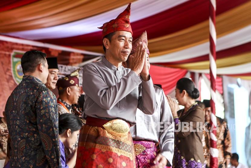 Presiden Joko Widodo memberikan salam saat penganugerahan gelar kehormatan adat Komering Provinsi Sumatera Selatan di halaman Griya Agung Palembang, Sumatera Selatan, Minggu (25/11/2018). 