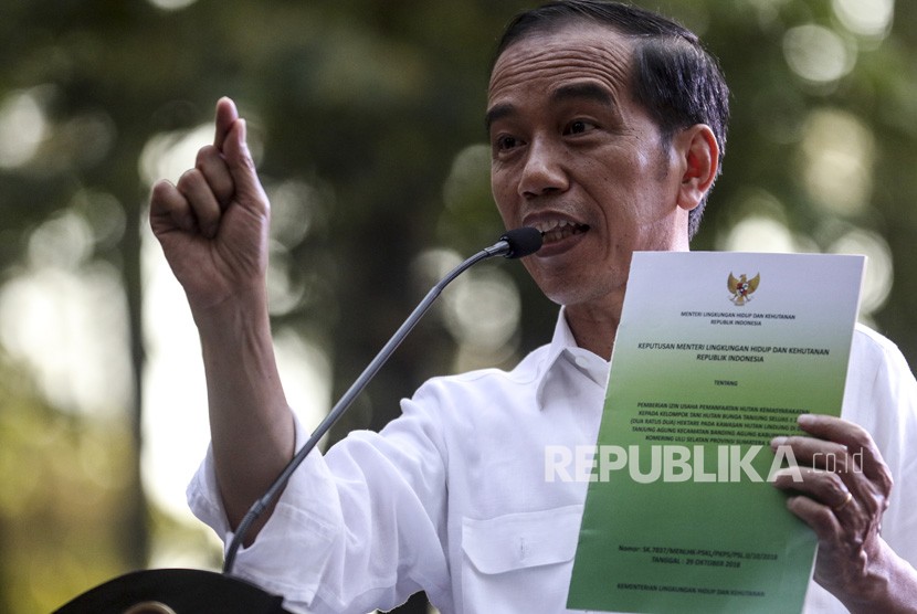 Presiden Joko Widodo memperlihatkan Surat Keputusan (SK) perhutanan sosial saat menghadiri penyerahan Surat Keputusan tersebut di taman hutan wisata punti kayu Palembang, Sumatera Selatan, Ahad (25/11/2018).