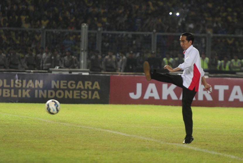Presiden Joko Widodo menendang bola saat membuka laga final Piala Bhayangkara antara Persib Bandung dengan Arema Cronus di Stadion Utama Gelora Bung Karno, Jakarta, Ahad (3/4). 