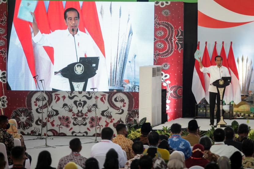 Presiden Joko Widodo (Jokowi) mengangkat sertifikat tanah warga saat penyerahan sertifikat tanah untuk rakyat Jawa Timur di Gelora Delta Sidoarjo, Jawa Timur, Senin (22/8/2022). 