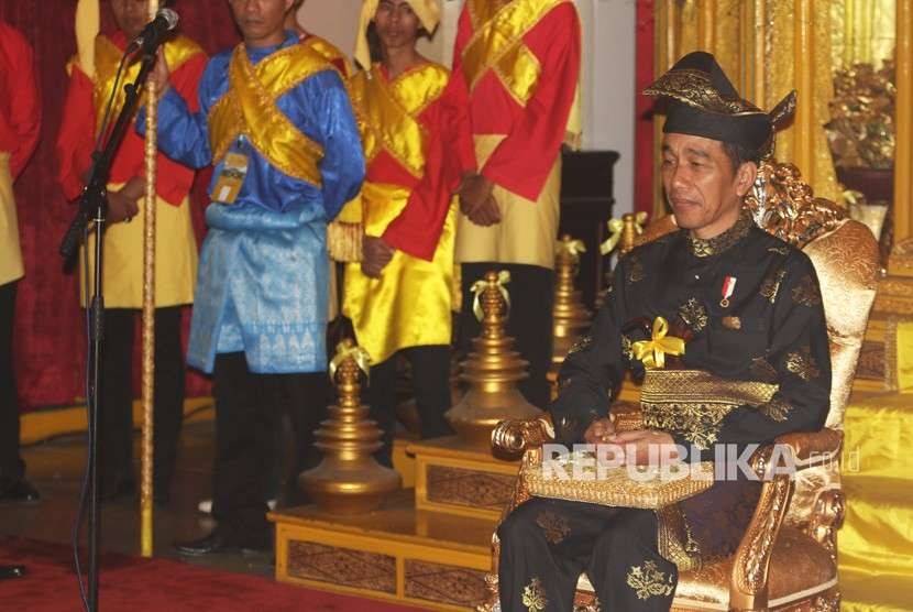 Presiden Joko Widodo mengenakan pakaian adat Melayu Deli saat mengikuti prosesi pemberian gelar adat Melayu Deli, di Istana Maimun, Medan, Sumatera Utara, Ahad (7/10). 