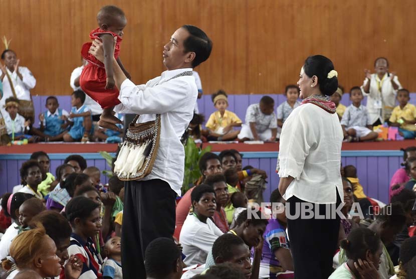 Presiden Joko Widodo menggendong seorang anak saat kunjungan kerja di Distrik Agats, Kabupaten Asmat, Papua, Kamis (12/4). 