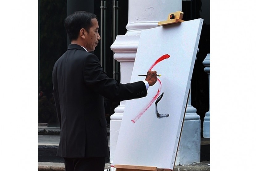 Presiden Joko Widodo menggoreskan tinta saat membuka pameran lukisan koleksi Istana dalam pameran 17l71 di Galeri Nasional, Jakarta, Senin (1/8)