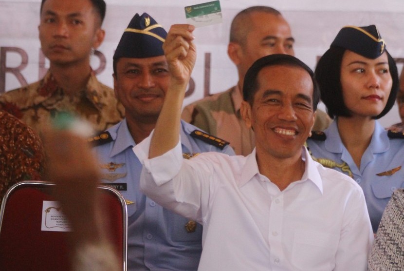 Presiden Joko Widodo menunjukkan Kartu Indonesia Sehat saat kunjungan kerja di Balaidesa Asrikaton, Pakis, Malang, Jawa Timur, Kamis (21/5). 